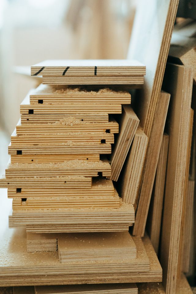 Close-up van gestapelde multiplexplaten in een werkplaats, die houtbewerkingsmaterialen en texturen toont